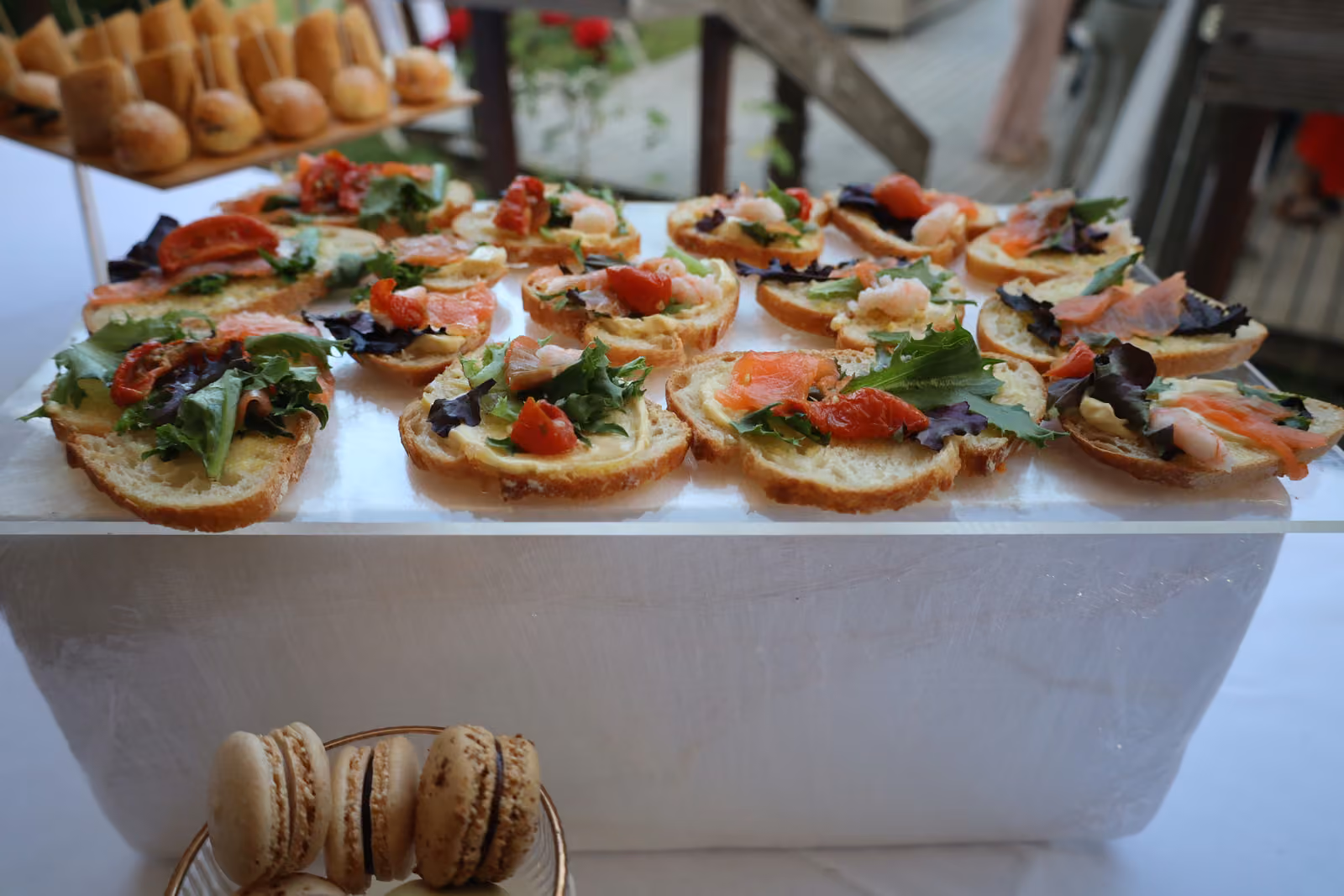 Bruschettas au saumon fumé, tomate séchée et roquette sur un présentoir blanc