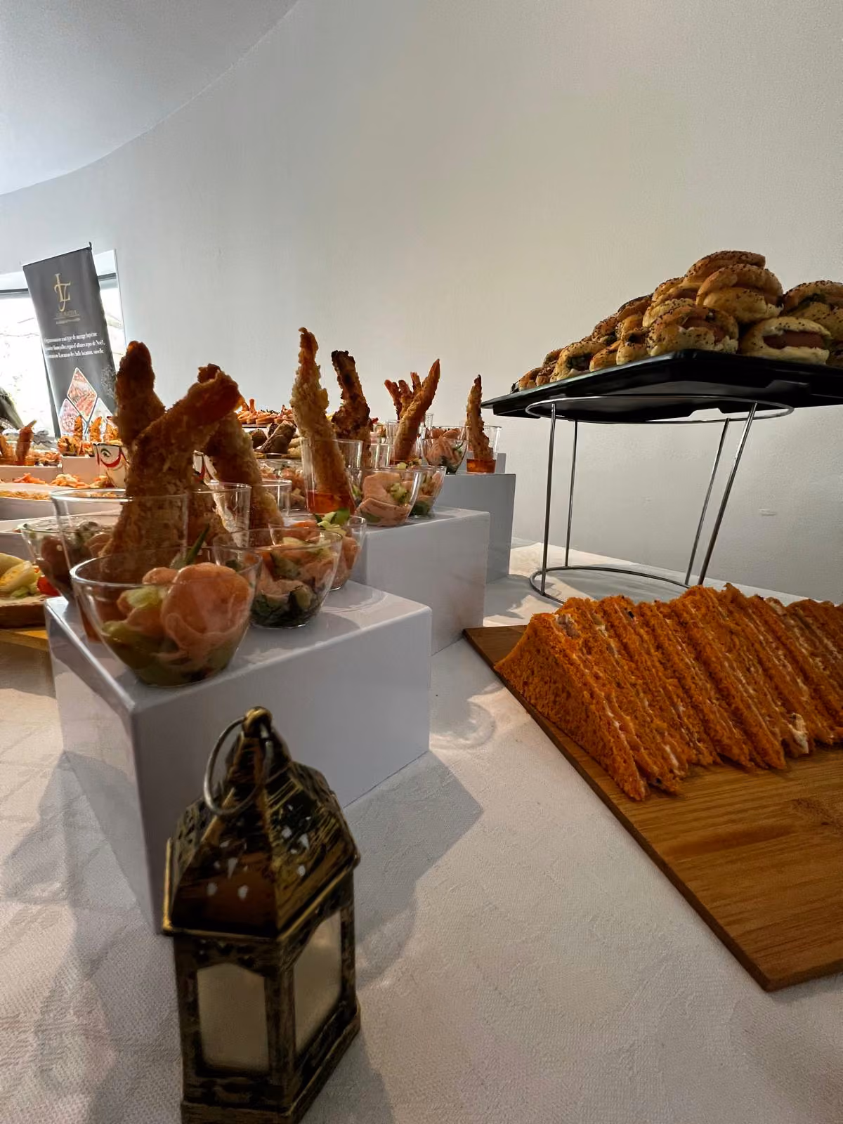 Buffet avec lanterne orientale, verrines de crevettes et sandwichs en triangle