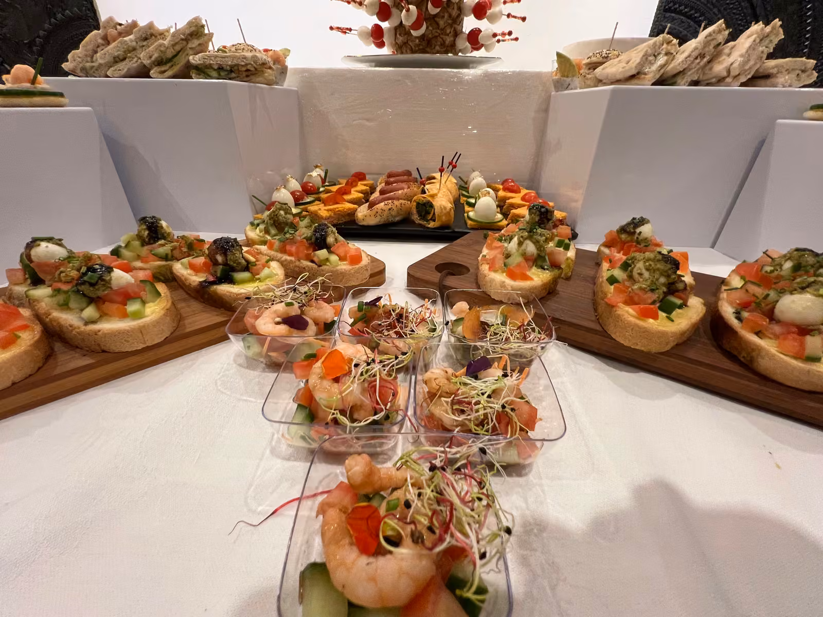 Canapés et verrines aux crevettes et jeunes pousses disposés en étoile sur planches en bois