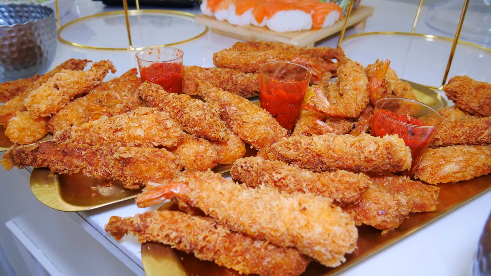 Plateau doré de crevettes panées et petites verrines de sauce cocktail