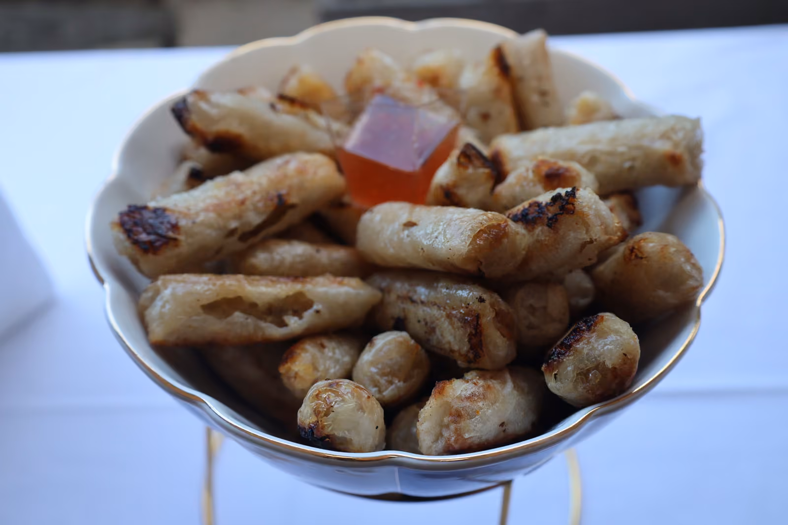 Coupe de nems grillés servis avec une sauce aigre-douce sur un présentoir doré