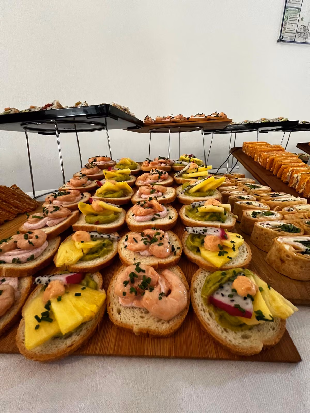 Tartines garnies de crevettes, de mangue et de fruit du dragon sur planche en bois